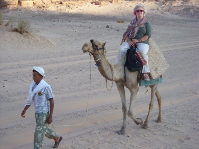 Emily on a camel being led.
