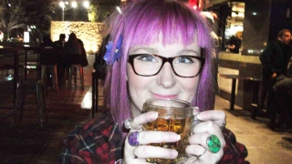 Emily Yates holding a beer with a big smile on her face