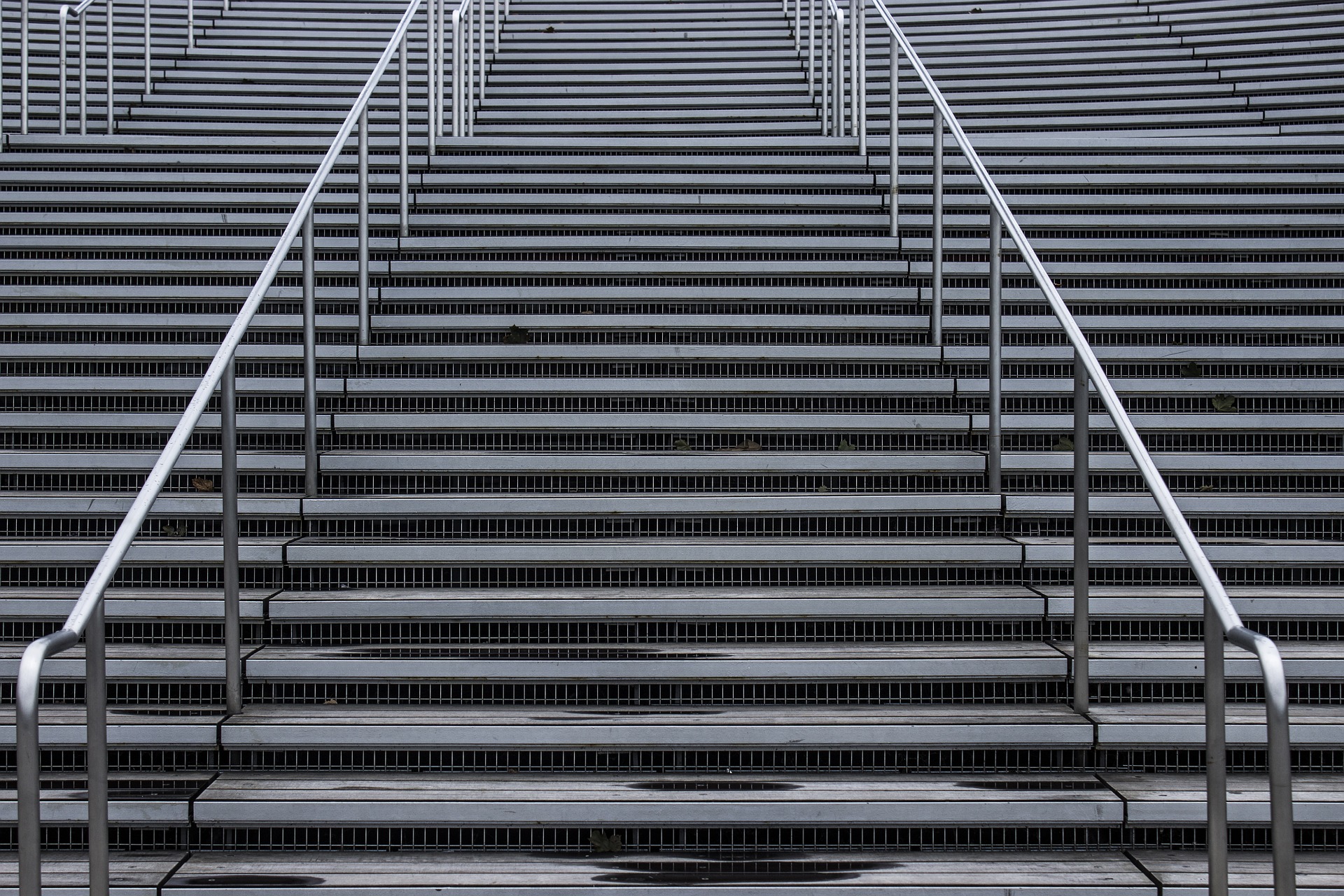 Image of grey stairs with silver handle bar representing the career ladder