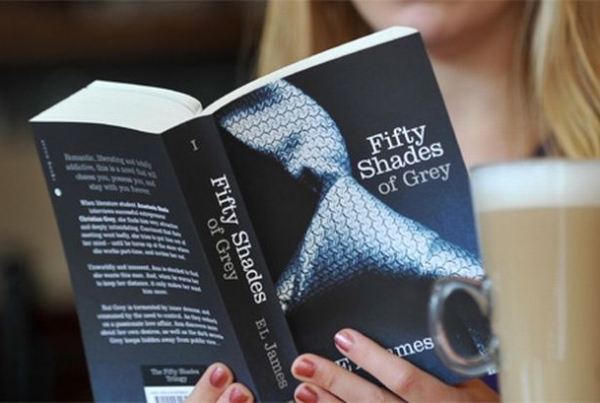 A woman read the 50 Shades of Grey book whilst enjoying a latte in a cafe