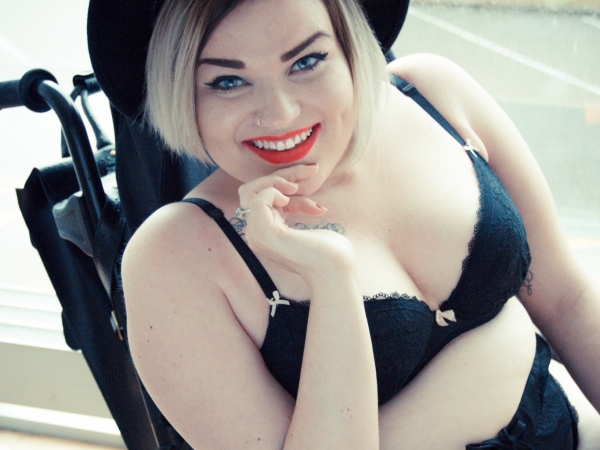 Kelly wearing a hat and black underwear, posing for the undressing disability campaign