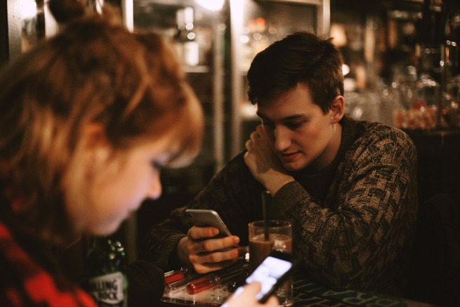 2 people in a public place on their phones