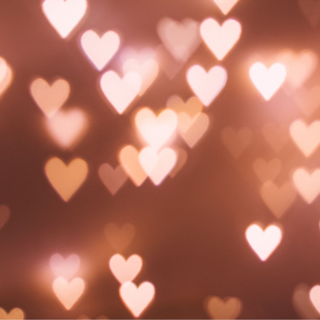 there are lots of white and pale pink hearts glowing against a dusky pink background