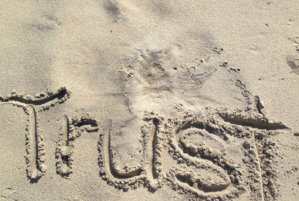 The word Trust written in the sand