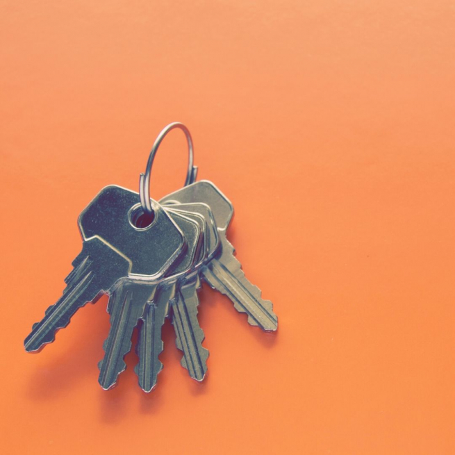 An orange background with a set of keys on a ring