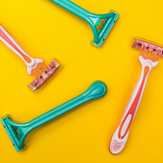 An image of 4 disposable razers on an orange background.