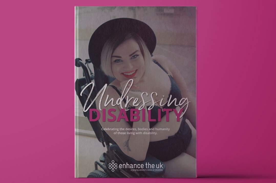 The Undresing Disability front cover, Kelly wearing a black bra, knickers and a hat smiling at the camera with red lipstick. She is sat in her wheelchair.