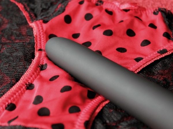 My partner hates my vibrator - red and black lacy knickers with a black vibrator positioned on the top