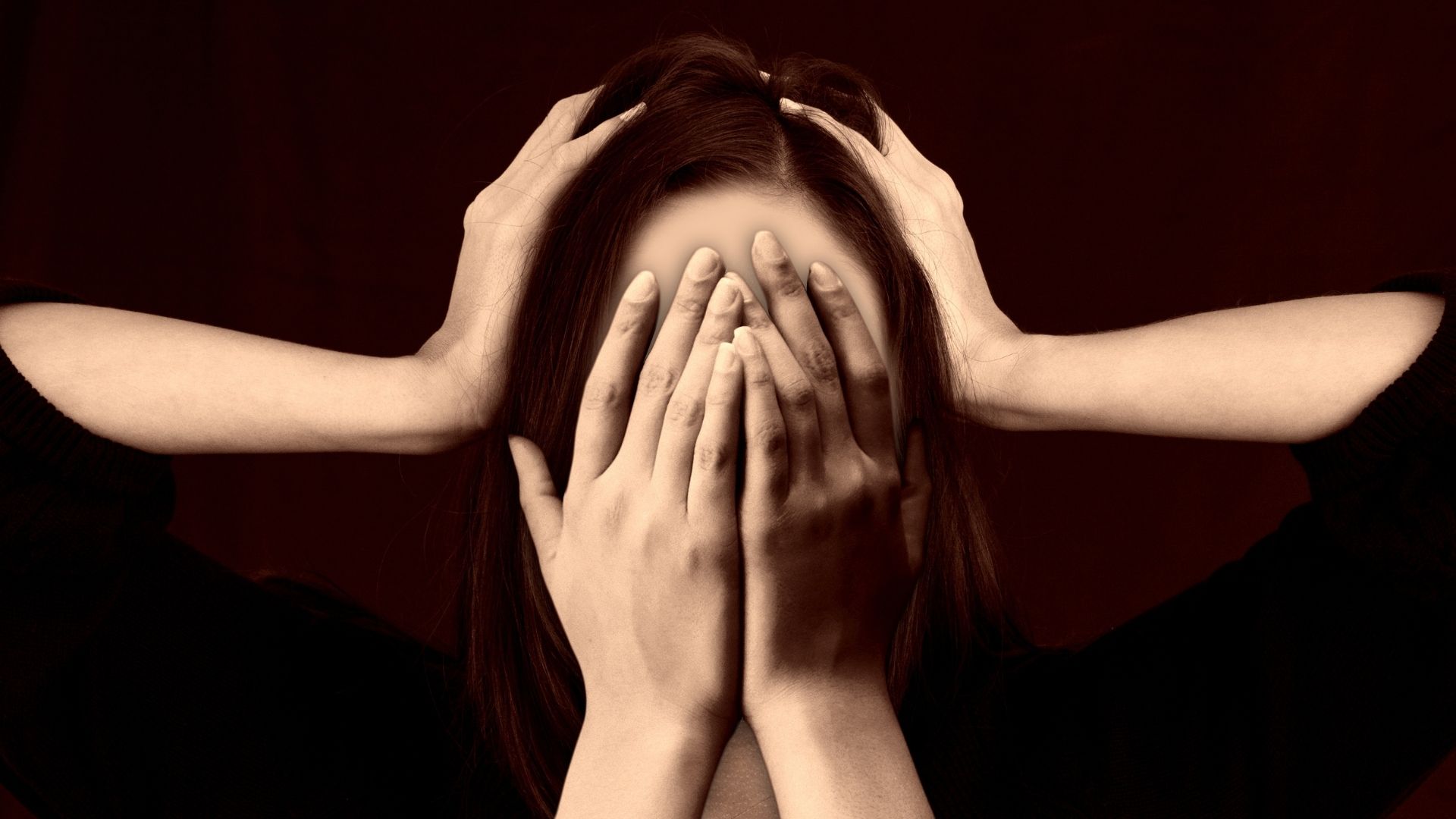 Stress Impacts Your Libido - a face covered with hands and another two hands pressing down on the side of the head