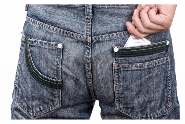I hate condoms - a rear view of a man wearing jeans with a condom wrapper visible in his back pocket