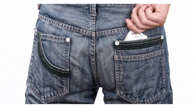 I hate condoms - a rear view of a man wearing jeans with a condom wrapper visible in his back pocket