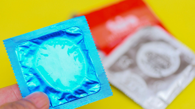 three condoms in blue, red and silver wrappers
