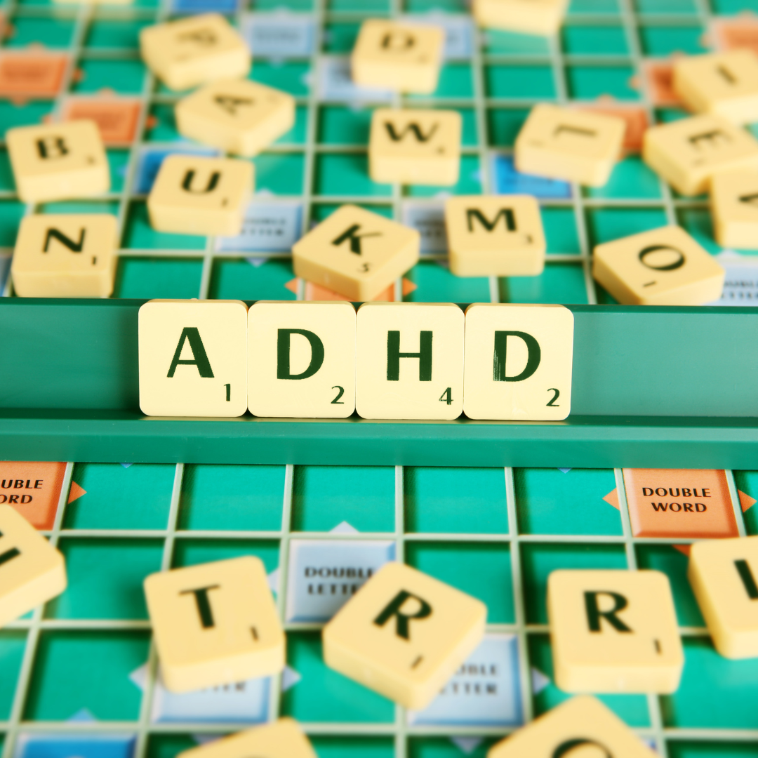 A photograph of a scrabble board, with the letter tiles spelling 'ADHD' cenred