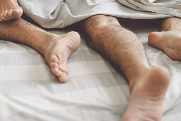 Photo of two peoples feet sticking out at the end of the bed.