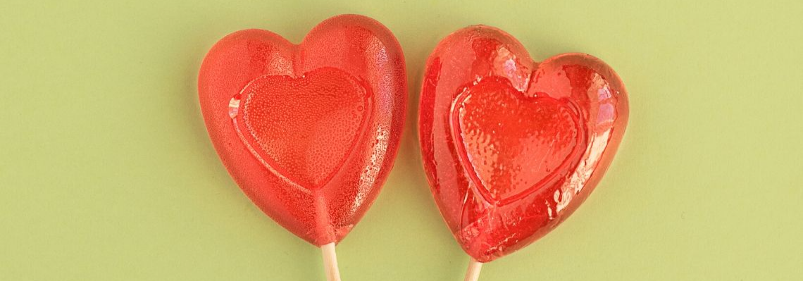 Two heart-shaped red lollipops.