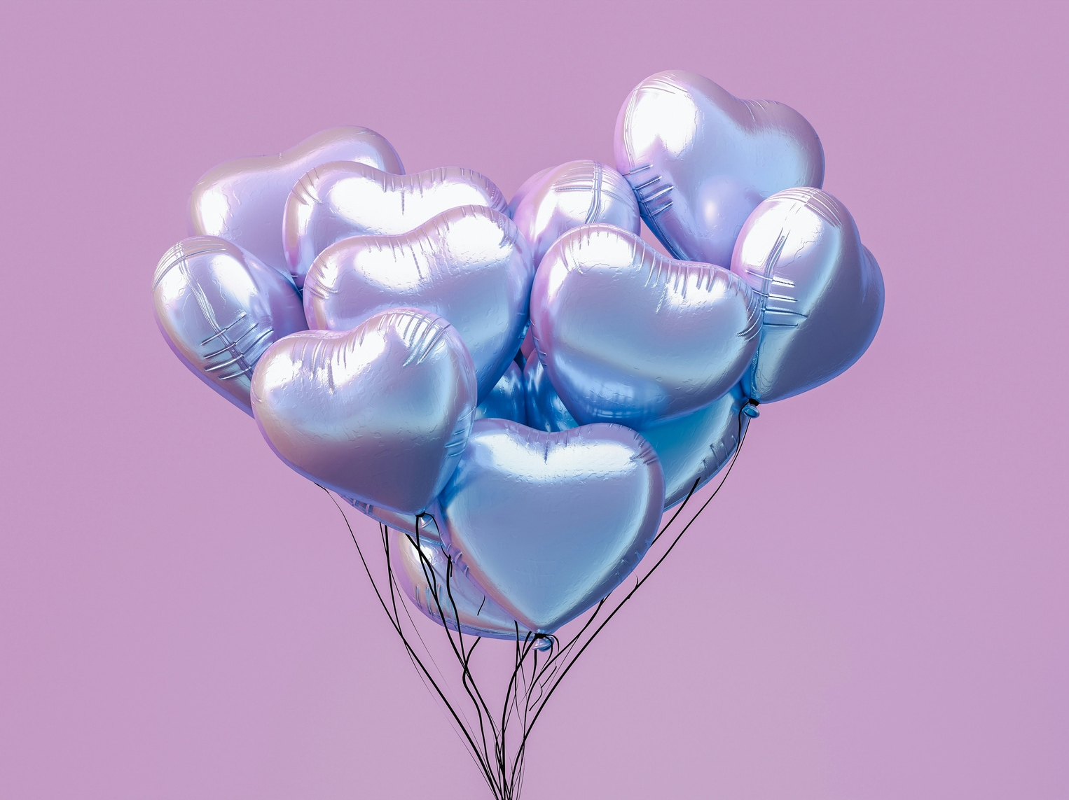 Silvery balloons in front of a flat colour background.