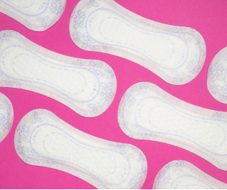 Periods and disability: A collection of white sanitary pads on a pink background arranged in a pattern