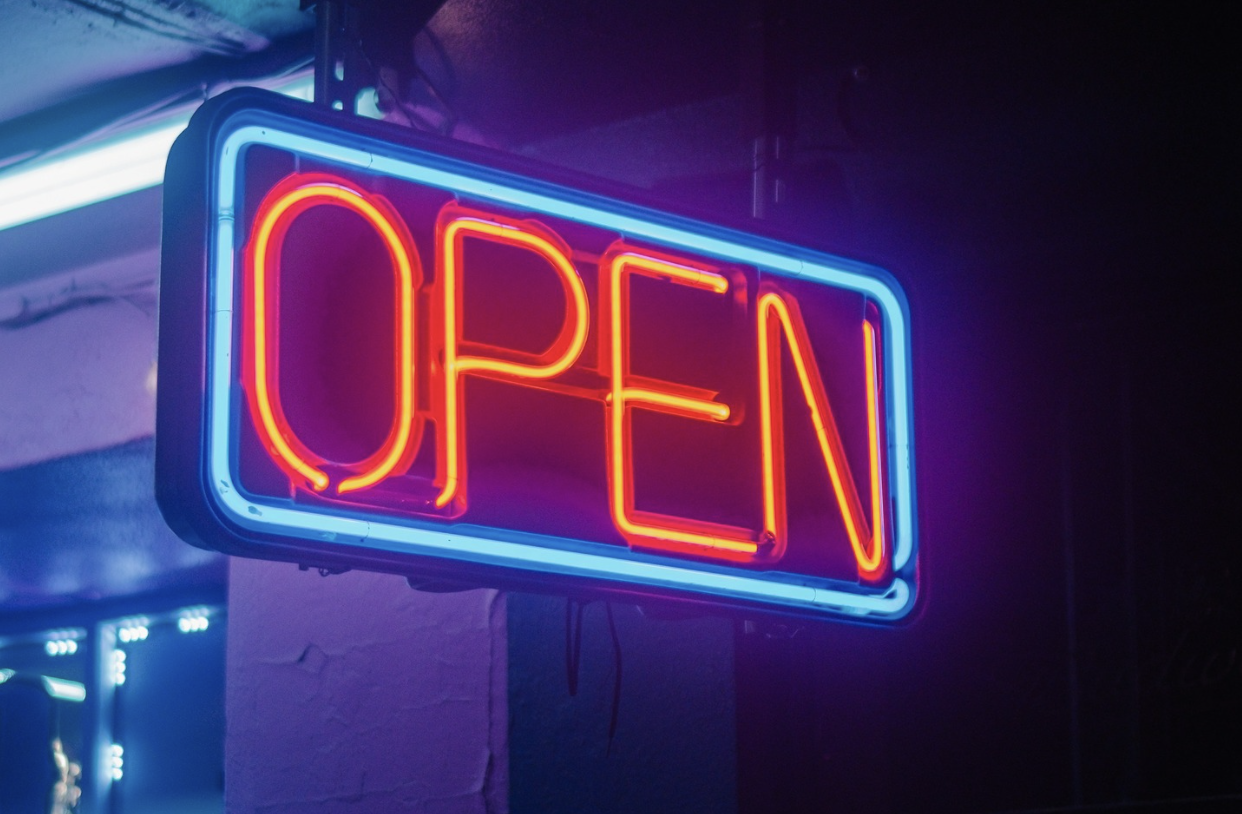A screenshot of a neon shop sign that says open